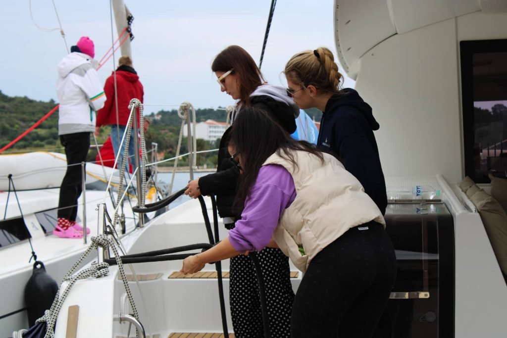 Instruktorica STARTING YOU nadgleda polaznice koje uče vezati konop na jedrilici